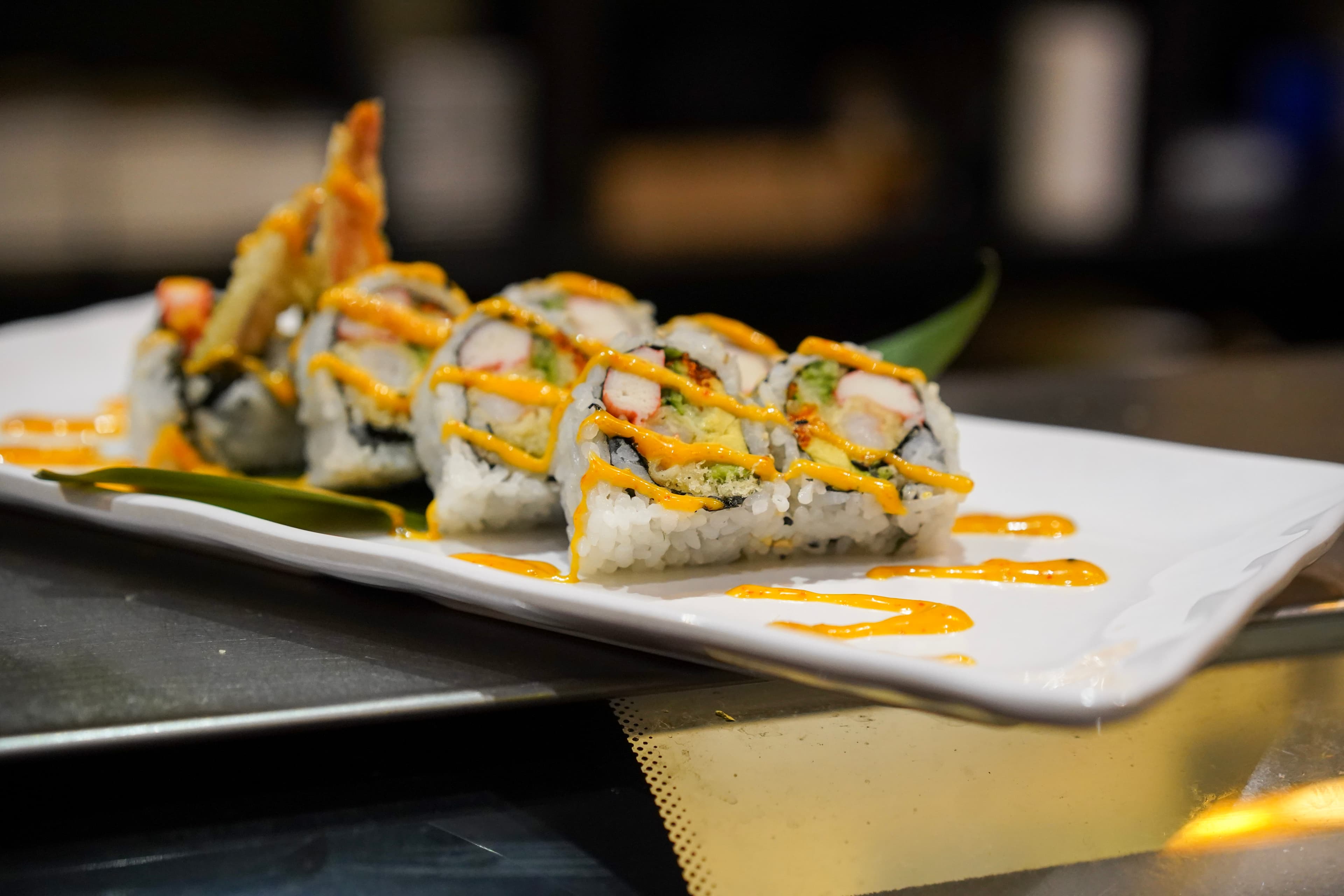 Selection of premium sushi rolls on bamboo leaf at Sparkly